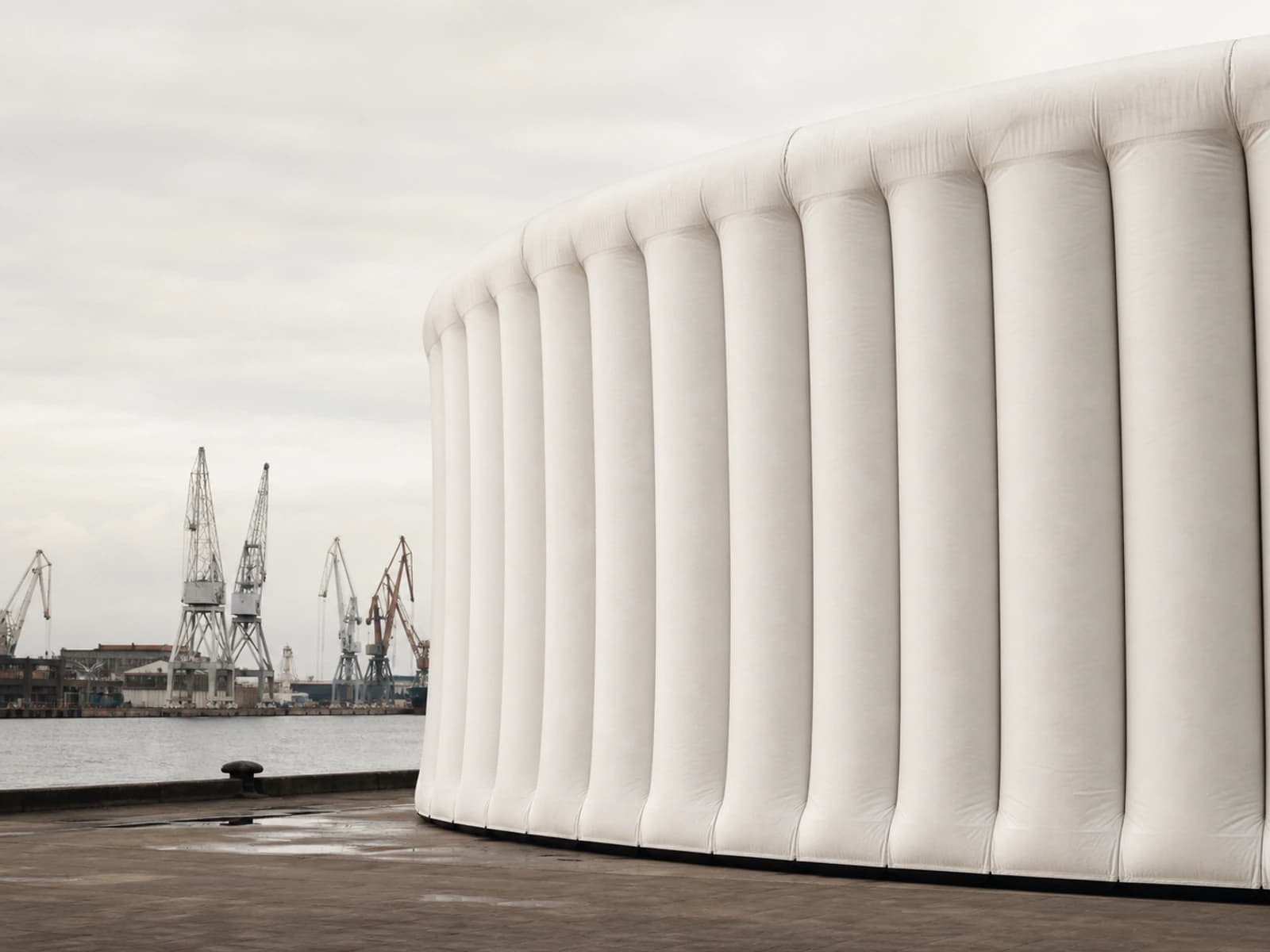 The circular envelope of Halo Pavilion seen across the dockyard